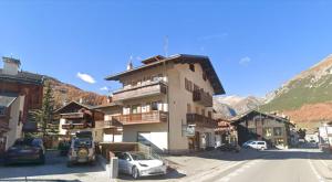 a building with cars parked on the side of a street at Chalet Edera Myholidaylivigno in Livigno