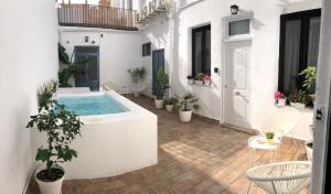 a courtyard with a hot tub and potted plants at Casa del Azucar in Motril