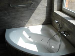 a white bath tub in a bathroom with a window at Schilfuferhaus in Hestoft