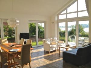 a living room with a dining room table and chairs at Schilfuferhaus in Hestoft