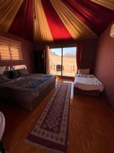 ワディ・ラムにあるWadi Rum Sand moon Camp &Tourのベッドルーム1室(ベッド2台付)、景色を望む窓が備わります。