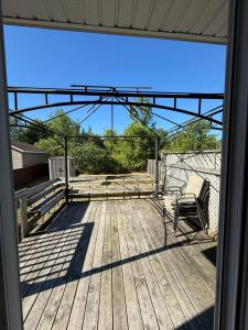 a deck with a chair sitting on top of it at Maison Acropole in Gatineau
