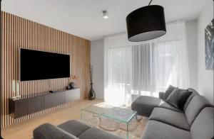 a living room with a couch and a flat screen tv at Efstaleiti 27 in Reykjavík