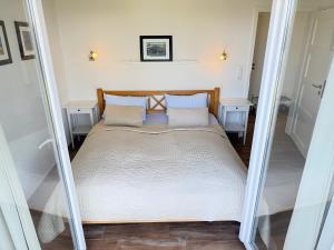 a bed with white sheets and pillows in a room at Rosenuferhaus in Hestoft