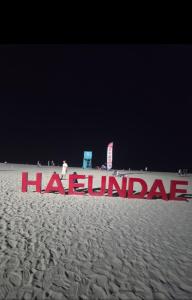 a sign on the beach with the wordshaquaza at 부산해운대바다품 in Busan