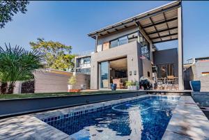 una casa con piscina di fronte a una casa di Luxury Smart 3bed Home a Pretoria