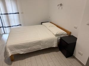 a small bedroom with a bed and a night stand at B&B Bene Vagienna in Turin +3 photos