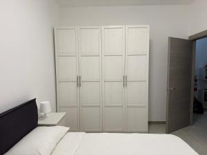 a bedroom with white cabinets and a white bed at B&B Bene Vagienna in Turin