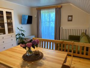 a living room with a table with flowers on it at Apartma Lesjak - pobeg v naravo 2 in Šmihel nad Mozirjem