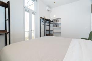 a white bedroom with a bed and a window at Sweet home in Turin
