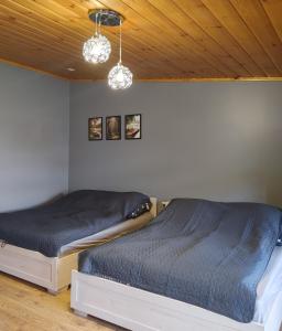 two twin beds in a bedroom with wooden ceilings at Apartamenty Jodłowa in Suwałki