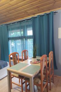 a dining room table and chairs with blue curtains at Apartamenty Jodłowa in Suwałki +21 photos