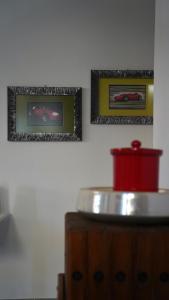 two pictures on the wall above a wooden cabinet at JD Suite Apartment near Ferrari in Fiorano Modenese