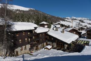 un groupe de bâtiments recouverts de neige sur une montagne dans l'établissement Villages Clubs du Soleil - VALMOREL, à Valmorel