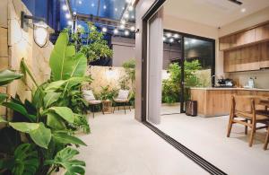 ein Zimmer mit Pflanzen und eine Küche mit einem Tisch in der Unterkunft Mei Villa - Ocean Park 3 in Ðình Loan