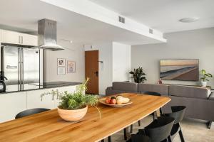 a kitchen and dining room with a wooden table and chairs at Gordon Beach Bright Spacious Stay in Tel Aviv
