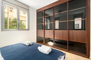 a bedroom with a blue bed and a large wooden cabinet at Gordon Beach Bright Spacious Stay in Tel Aviv