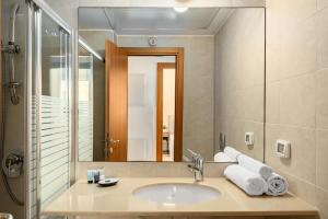 a bathroom with a sink and a mirror at Gordon Beach Bright Spacious Stay in Tel Aviv +46 photos