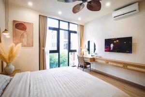 ein Schlafzimmer mit einem Bett, einem Schreibtisch und einem Fernseher in der Unterkunft Mei Villa - Ocean Park 3 in Ðình Loan + 26 Fotos