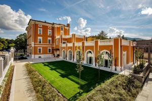 a large orange building with a lawn in front of it at Villa Miliani in Fabriano