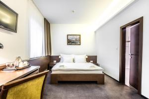 a hotel room with a bed and a desk at Penzion Central in Banská Bystrica