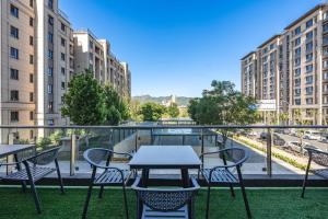 a table and chairs on a balcony with buildings at Elong Hotel Beijing Chang'an Tianjie Bridge Huiying Metro Station Branch in Beijing