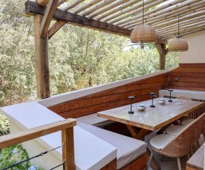 an outdoor patio with a wooden table and chairs at Casetta Mare di Cala Rossa in Cala Rossa