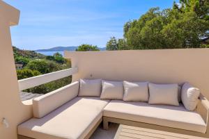 a white couch on a balcony with a view of the ocean at Casetta Mare di Cala Rossa in Cala Rossa +28 photos