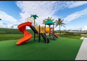 a playground with slides on a green lawn at Costa do Sauípe 5 suítes, piscina, hidromassagem e área de lazer completa in Mata de Sao Joao