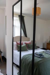 a bedroom with a bed with a mirror at THE LOFT Alnmouth in Alnmouth +8 photos