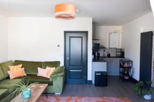 a living room with a green couch and a table at THE LOFT Alnmouth in Alnmouth