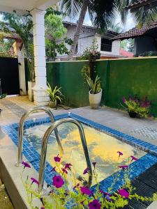 a swimming pool with two faucets in a yard at Ocean Pearl Cottage in Ahungalla