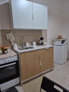 a kitchen with a sink and a stove and a microwave at House Mari in Catania