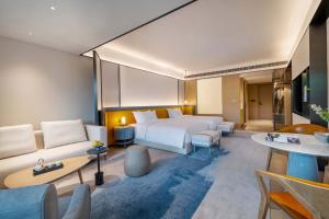 una habitación de hotel con una cama y un sofá en XUANDE GATE HOTEL, en Hsü-chia-ch'iao