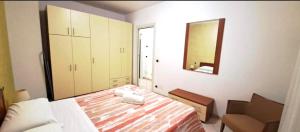 a small bedroom with a bed and a mirror at Eli's House in Bardolino sul Garda in Bardolino +4 photos