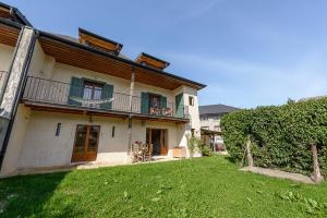 ein großes Haus mit einem Garten davor in der Unterkunft La Grande Mélodie - Maison familiale avec jardin in Saint-Jorioz