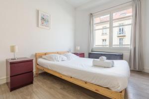 Un dormitorio con una cama con una computadora portátil encima. en Hortensia - Pause nancéienne, en Vandoeuvre-lès-Nancy