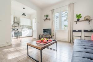 Una sala de estar con una mesa con un bol de fruta encima. en Hortensia - Pause nancéienne, en Vandoeuvre-lès-Nancy