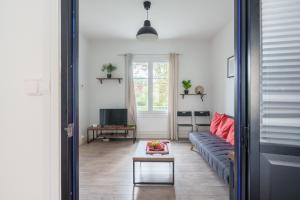 una sala de estar con un sofá y una mesa en Hortensia - Pause nancéienne, en Vandoeuvre-lès-Nancy