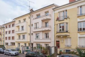 Un edificio de apartamentos con coches aparcados delante. en Hortensia - Pause nancéienne, en Vandoeuvre-lès-Nancy