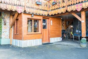 a building with a wooden door and a bike parked outside at Bas De Chalet Lout'Chi Valfréjus in Valfréjus