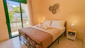 une chambre avec un lit et une grande fenêtre dans l'établissement Villa Phoebe, à Kefalás 33 autres photos