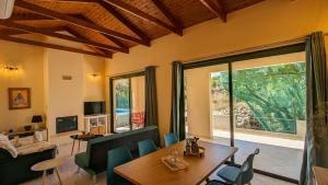 un salon avec un canapé, une table et des chaises dans l'établissement Villa Phoebe, à Kefalás