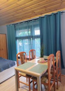 a dining room table and chairs with a table and a window at Apartamenty Jodłowa in Suwałki