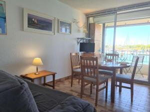 a living room with a table and chairs and a television at T2 cabine - CAP D'AGDE CT300-124 in Cap d'Agde