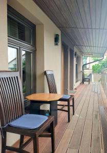 a wooden table and chairs on a wooden deck at Apartamenty Jodłowa in Suwałki