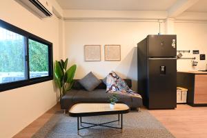 バンコクにあるCozy Oldtown Near MRT HuaLumpongのリビングルーム(ソファ、冷蔵庫付)