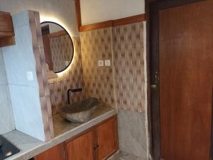 Un baño con un lavabo de piedra y un espejo. en Sunset villa munduk, en Munduk