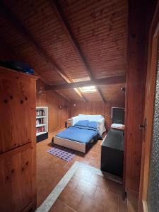 una camera da letto con un letto in una stanza di legno di Casa Viola a Chianocco