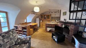 a living room with a fireplace and a kitchen at Casa Viola in Chianocco